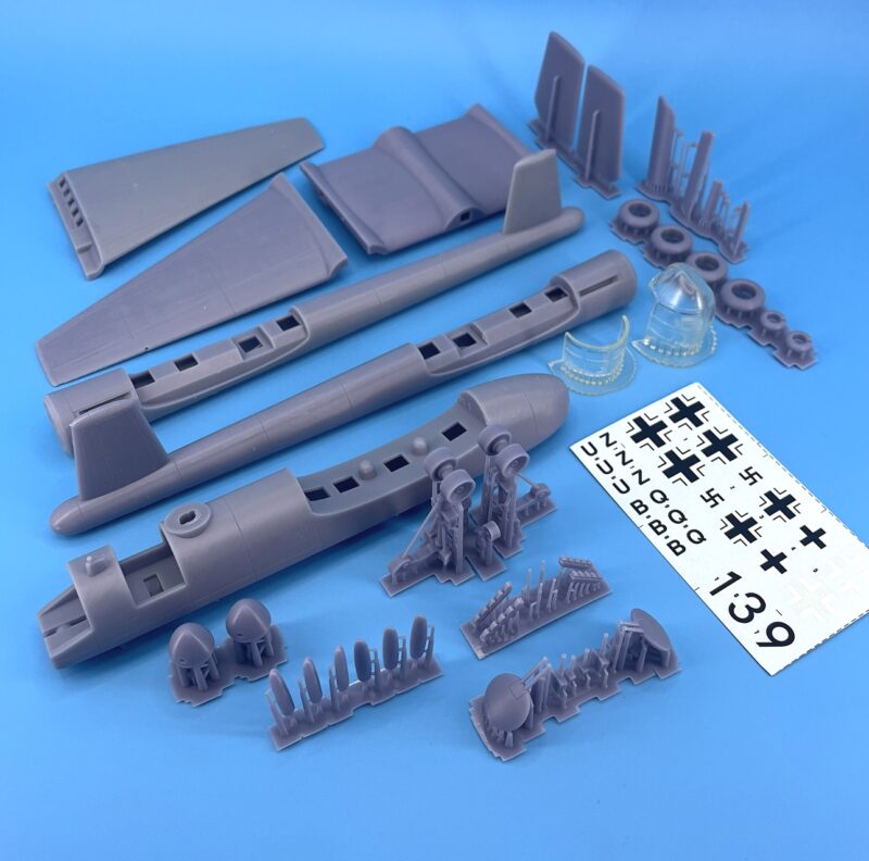 Plastic model kit assembly tools and parts on blue background.